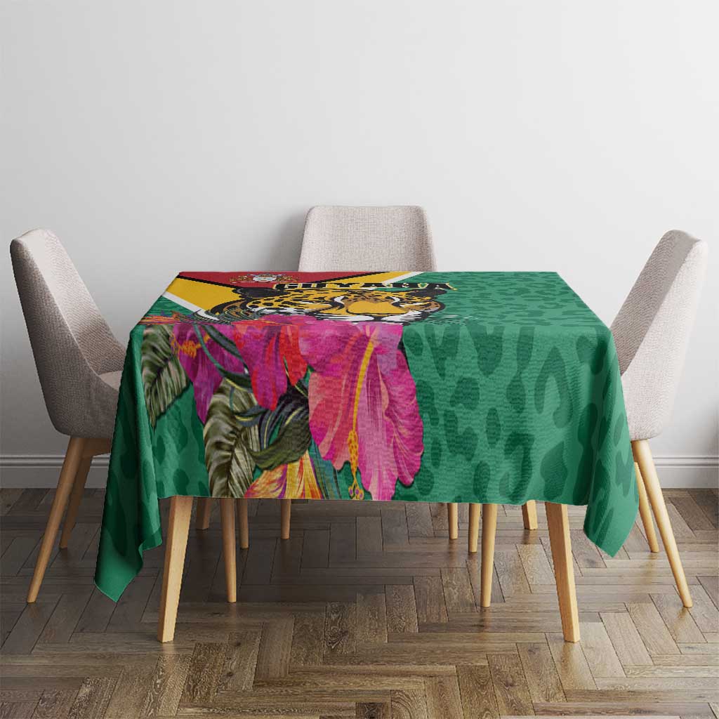 Green tablecloth with jaguar and pink tropical flowers over table surface