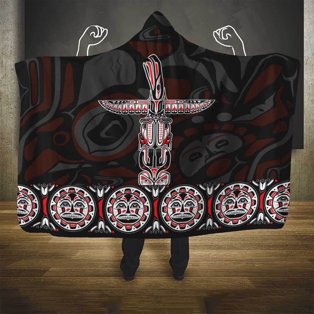 Hooded blanket with large red-and-white totem motif and repeated face border