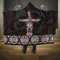 Hooded blanket with large red-and-white totem motif and repeated face border