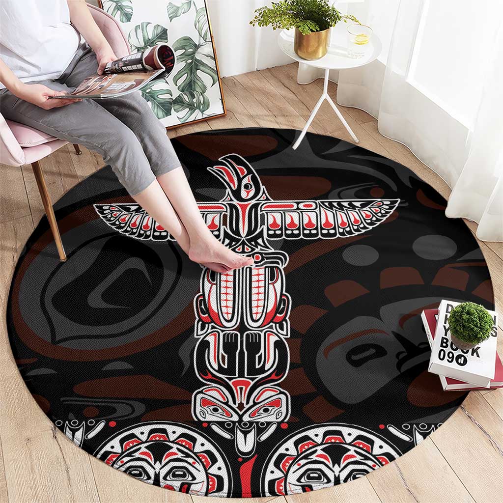 Black round carpet with central totem figure and red-and-white border motifs