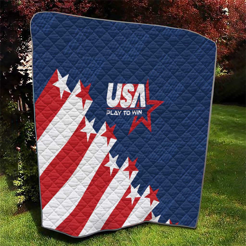 Blue quilt blanket with USA logo, stars, and red-and-white diagonal stripes, outdoor display