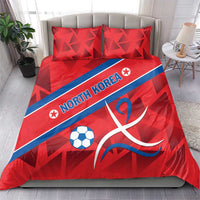 Red North Korea themed duvet set with soccer ball and ribbon emblem, on bed with pillows