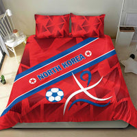 Red North Korea duvet and pillows with soccer ball and ribbon emblem, centered on bed