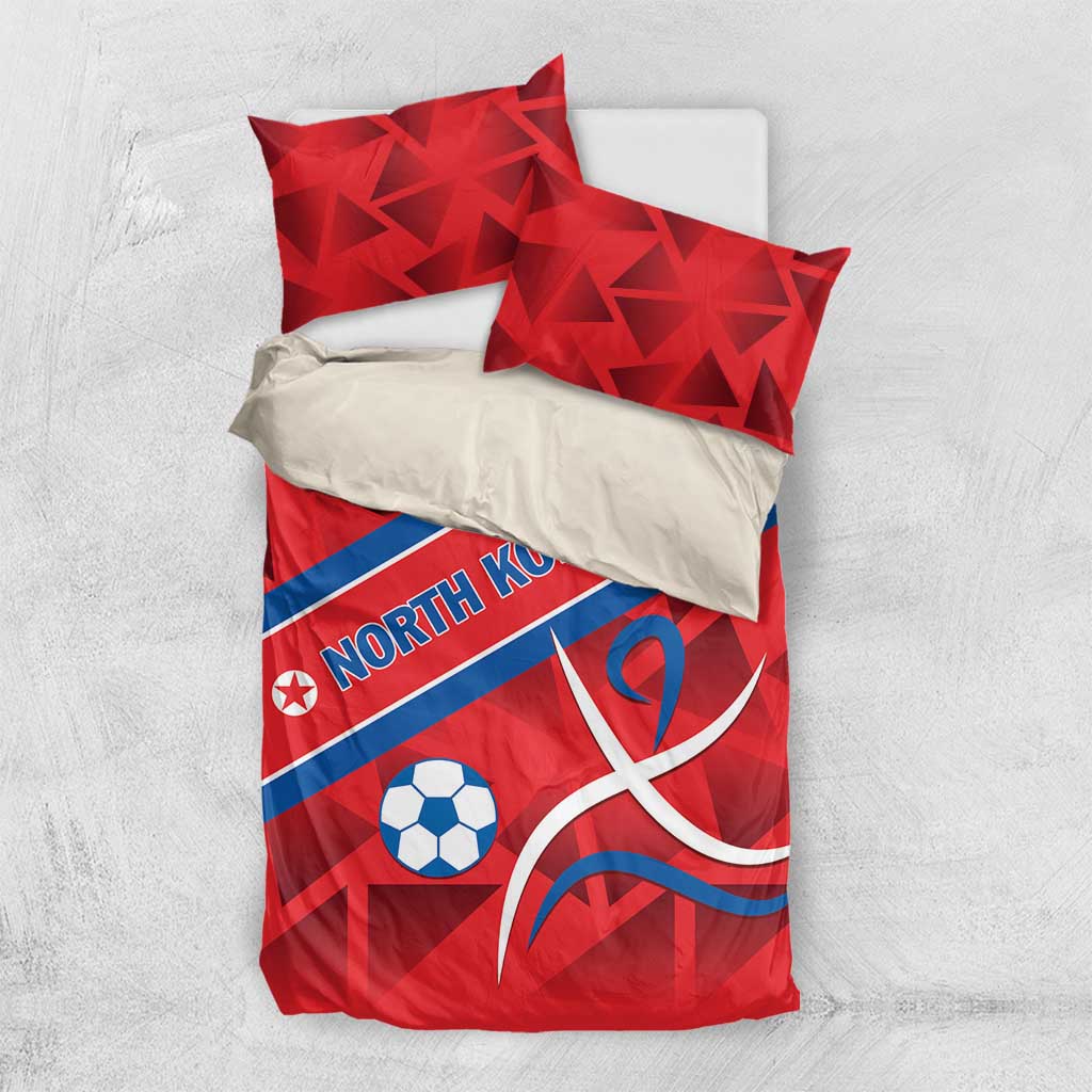 Red bedding set with North Korea text, soccer ball, and ribbon emblem, two top pillows