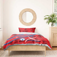 Red duvet set with North Korea text, soccer ball, and ribbon emblem, folded over bed