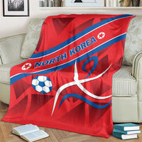 Red North Korea football blanket with blue diagonal stripe and soccer ball, large white emblem