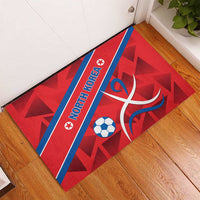 Red rubber doormat with blue border stripe, NORTH KOREA text, soccer ball and graphic