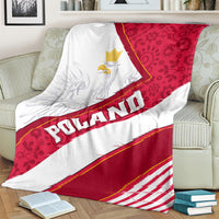 Red and white Poland eagle blanket draped on couch with diagonal POLAND lettering