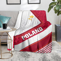 Red and white Poland eagle blanket over sofa, showing crest and diagonal POLAND lettering
