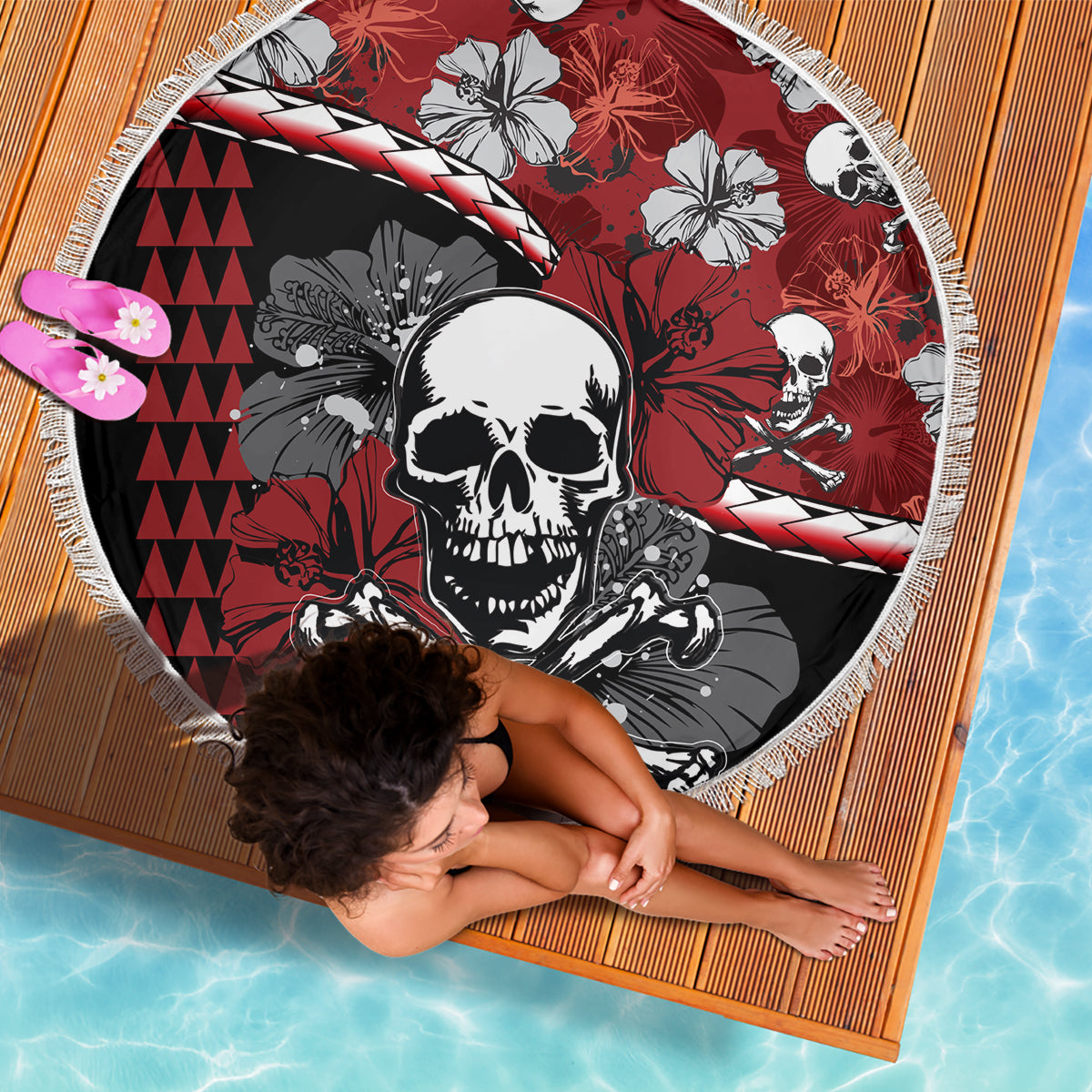 Round beach blanket with skull and hibiscus pattern, red and black tones, white fringe