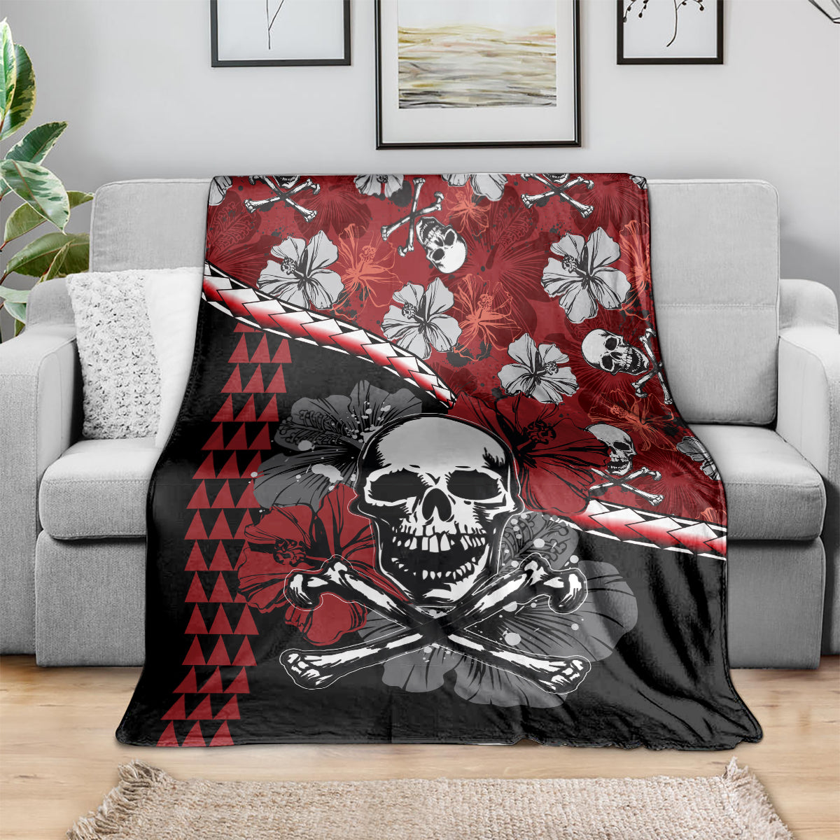 Red, black, and white Halloween blanket draped on a sofa, skull and hibiscus tiki pattern