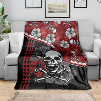 Red, black, and white Halloween blanket draped on a sofa, skull and hibiscus tiki pattern