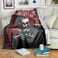 Red and black Halloween blanket draped over a sofa arm, skull with crossbones and hibiscus