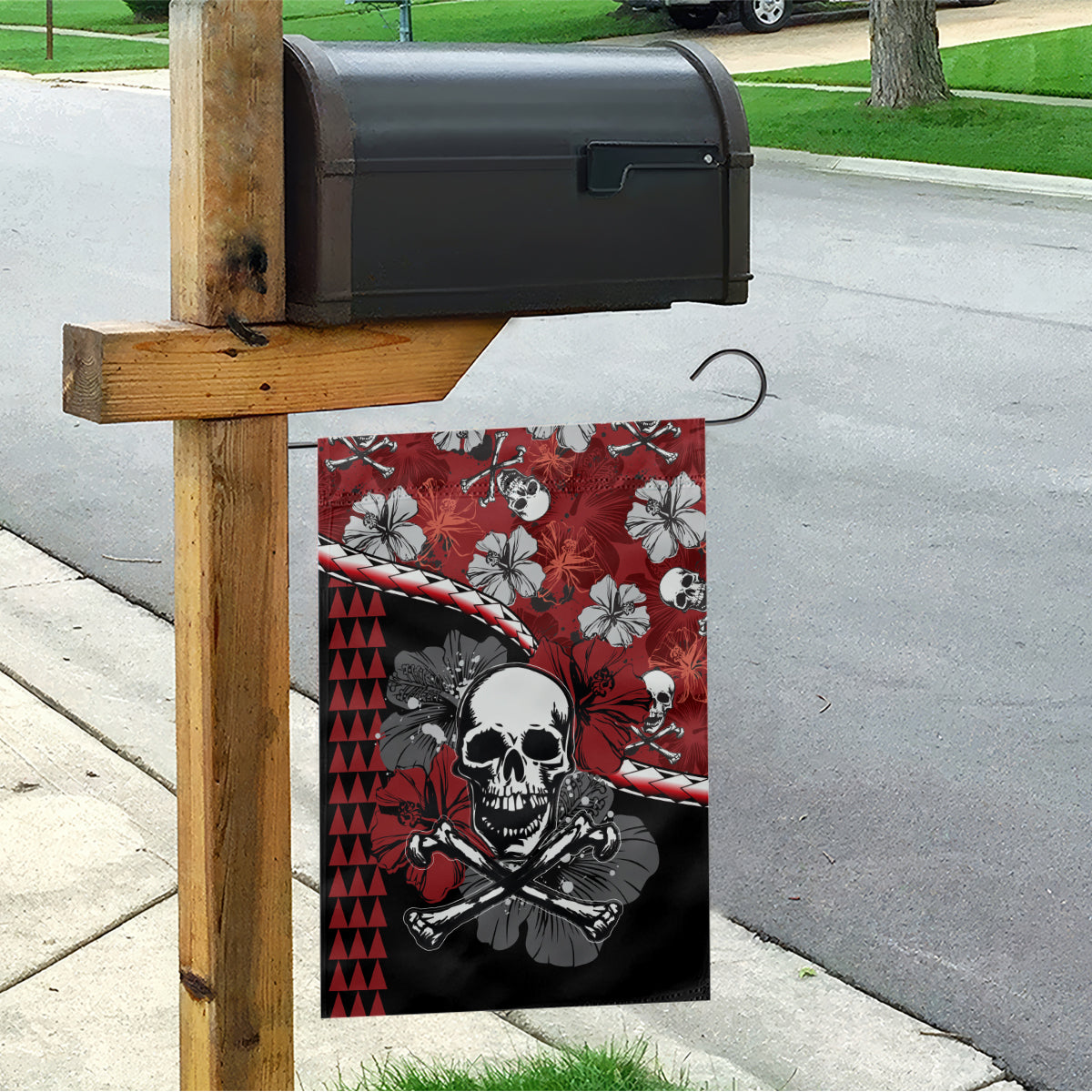 Red and black garden flag with skull and crossbones, hanging on a yard post