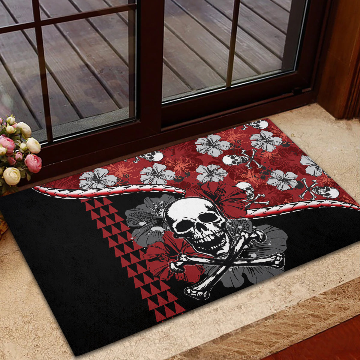 Red and black rubber doormat featuring a skull and hibiscus blossoms with ribbon border.