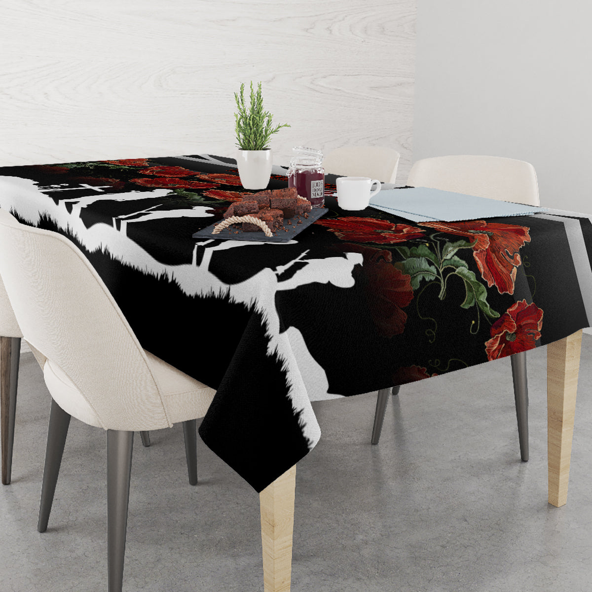Black tablecloth featuring white silhouette figures and red poppies with green leaves