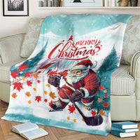 Teal Christmas blanket on a couch with Santa and “Merry Christmas” lettering