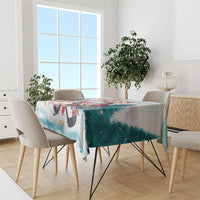 Hockey-themed Christmas tablecloth with Santa artwork, teal fabric draped over table
