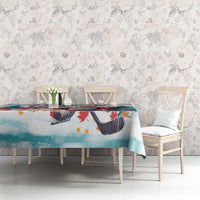 Christmas tablecloth featuring Santa and hockey skates, teal and red, over dining table