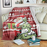 Red Christmas blanket with Santa, green tree, snowflakes, and gift on striped knit