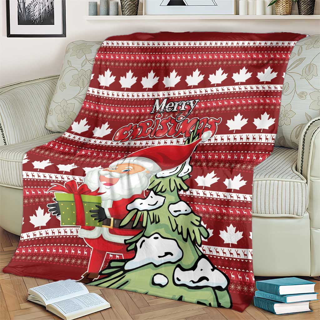Red Christmas blanket on couch showing Santa with a present, pine trees, and maple leaf motifs