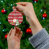 Red round ceramic Christmas ornament with hanging loop; Santa and Merry Christmas on maple leaf stripes.