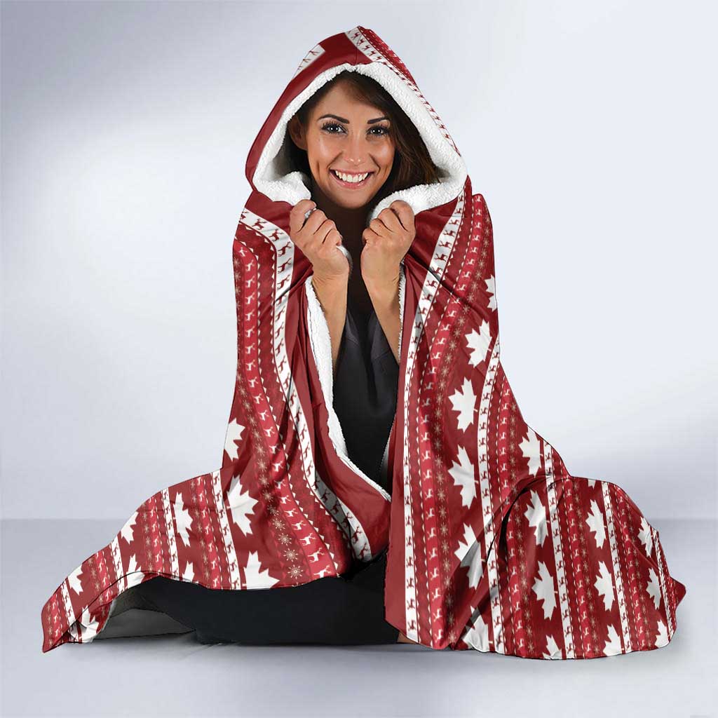 Red hooded Christmas blanket with maple leaf pattern and Santa graphic, worn with hood up