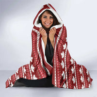 Red hooded Christmas blanket with maple leaf pattern and Santa graphic, worn with hood up