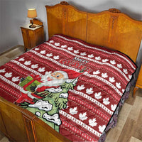 Red bed quilt with maple leaf stripes and Santa holding a gift, “Merry Christmas” in center