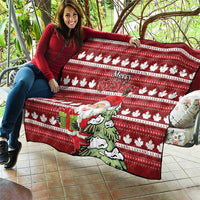 Red Christmas quilt with maple leaf pattern, Santa holding gift, and “Merry Christmas” text