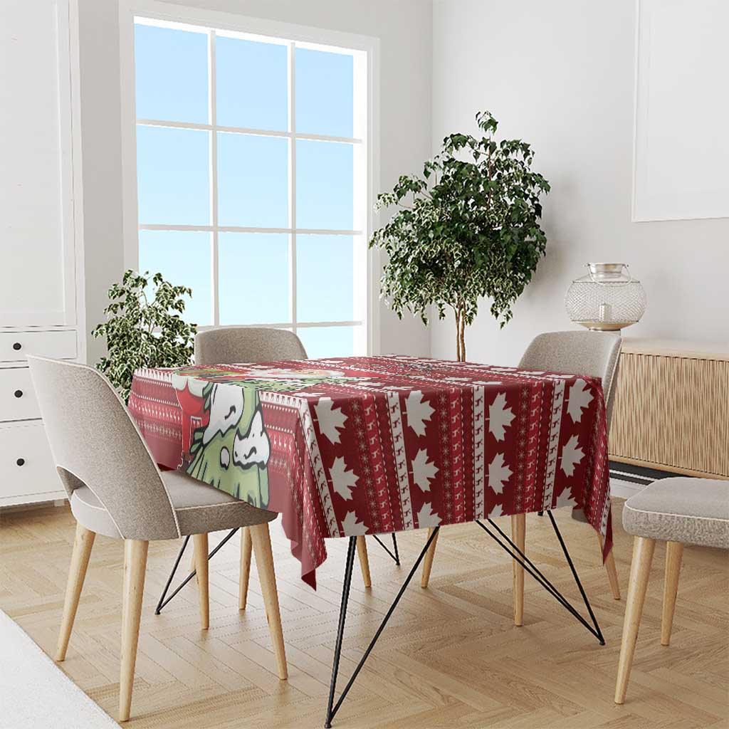 Red Christmas tablecloth on rectangular table with repeating maple leaf and Santa motifs