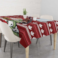 Red Christmas tablecloth covering table with Santa cartoon and white maple leaf icons