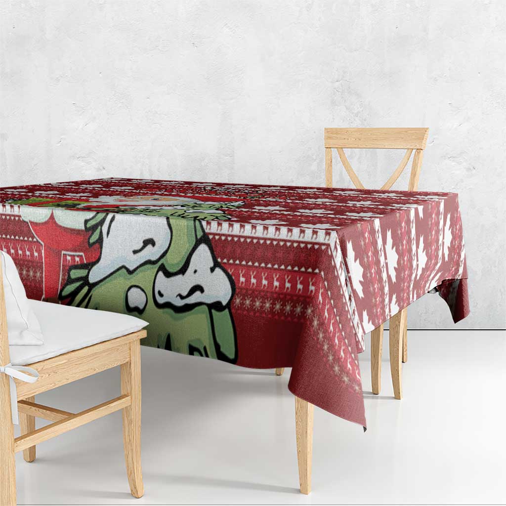 Red Christmas tablecloth draped on dining table with Santa graphic and maple leaf motifs