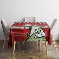 Red Christmas tablecloth on dining table, bold Santa illustration over maple leaf stripes