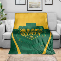 Green and yellow South Africa Cricket blanket on a couch with bold team logo