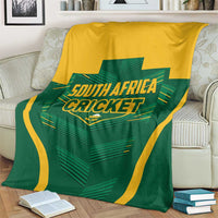 Green and yellow blanket with South Africa Cricket text, spread over armchair