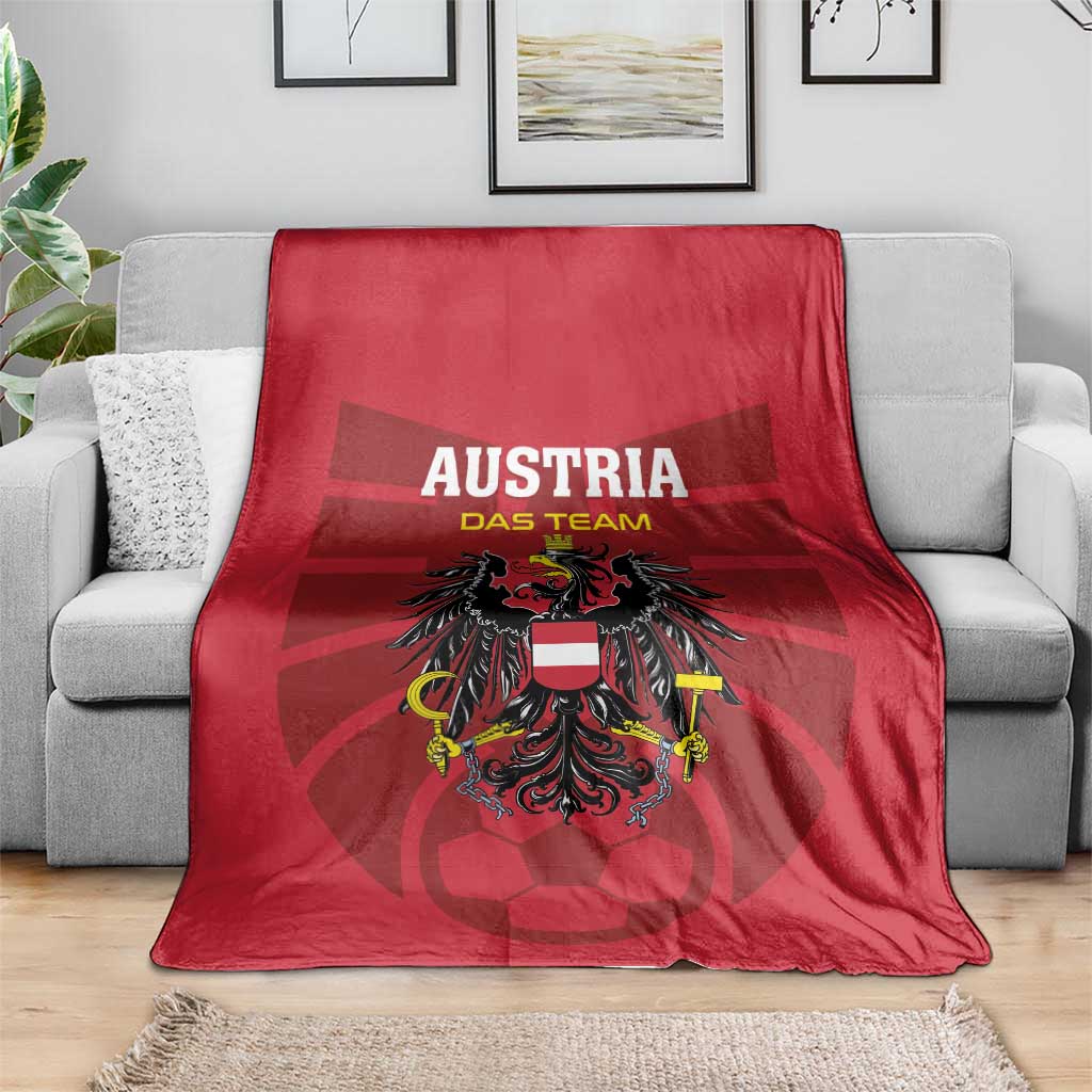 Red Austria football blanket with bold team logo, folded over gray couch