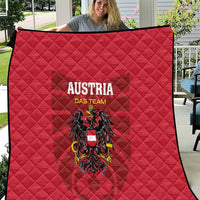 Red quilt blanket with 'AUSTRIA DAS TEAM' lettering and black eagle crest