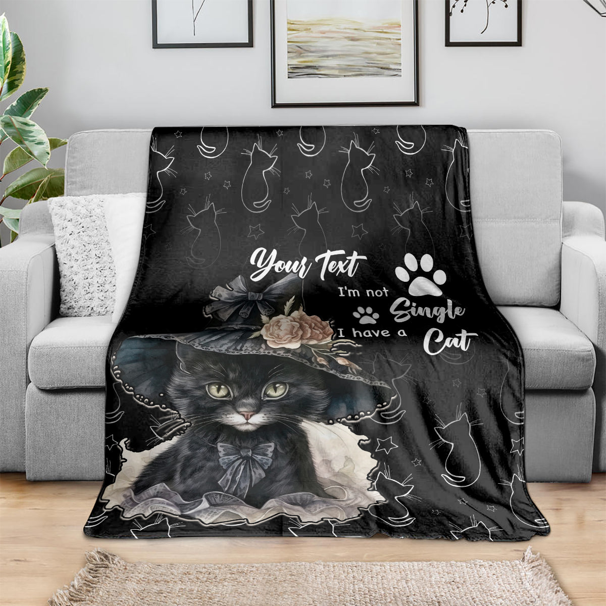 Black cat throw blanket draped over a sofa with large cat face artwork
