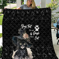 Black quilt blanket with quilted pattern and large gray cat graphic with paw prints