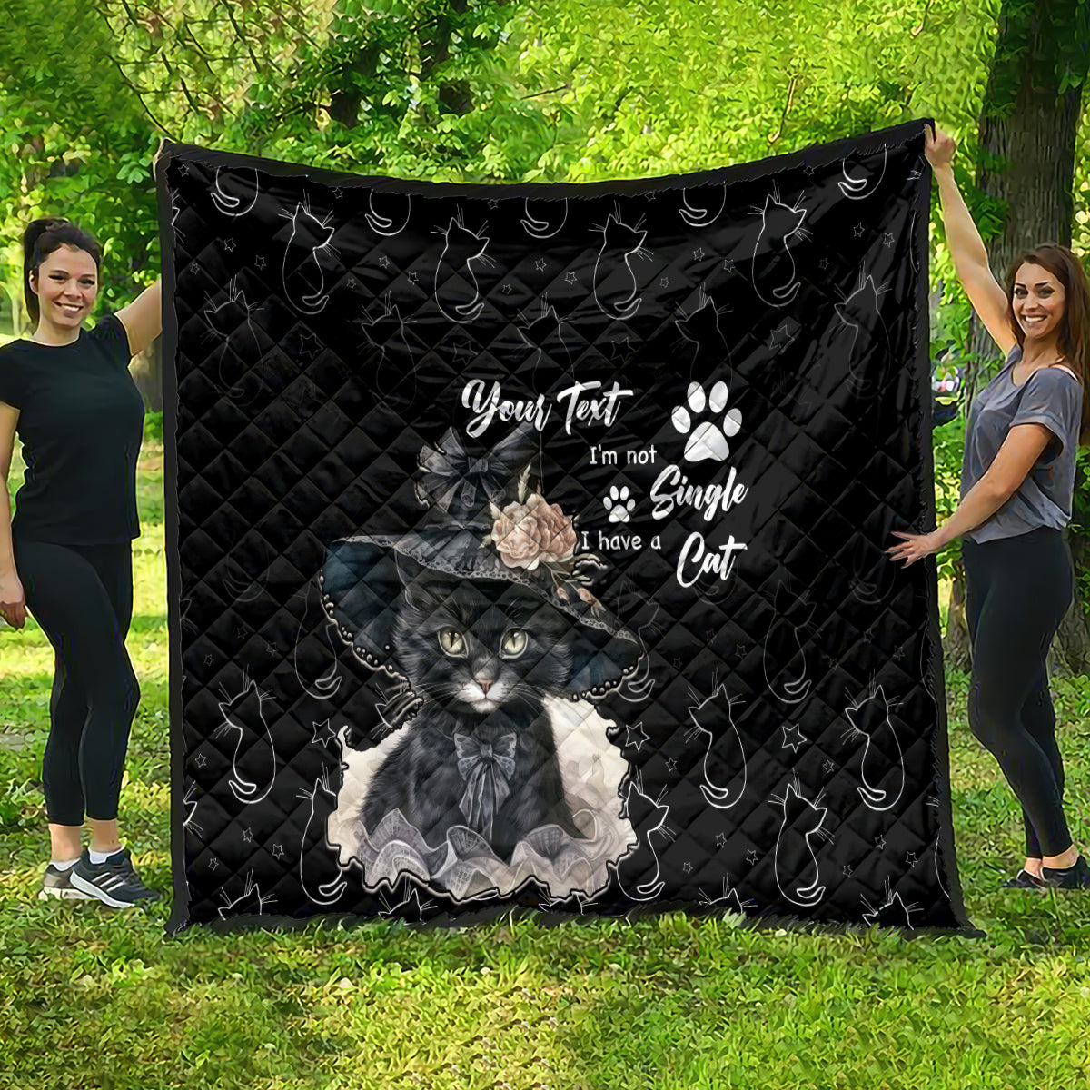 Black quilt blanket featuring gray cat artwork, paw prints, and decorative text in center