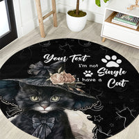 Black round cat-themed area rug with large cat face, paw prints, and floral graphic