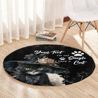 Black round cat area rug with cat portrait, paw prints, and rose floral artwork