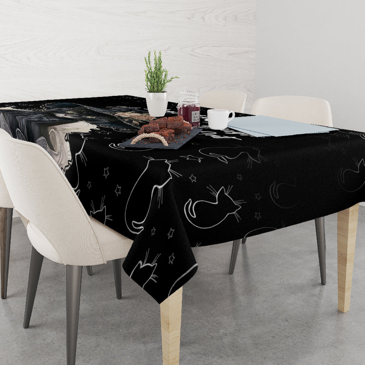 Black cat-pattern tablecloth draped over rectangular dining table with chairs