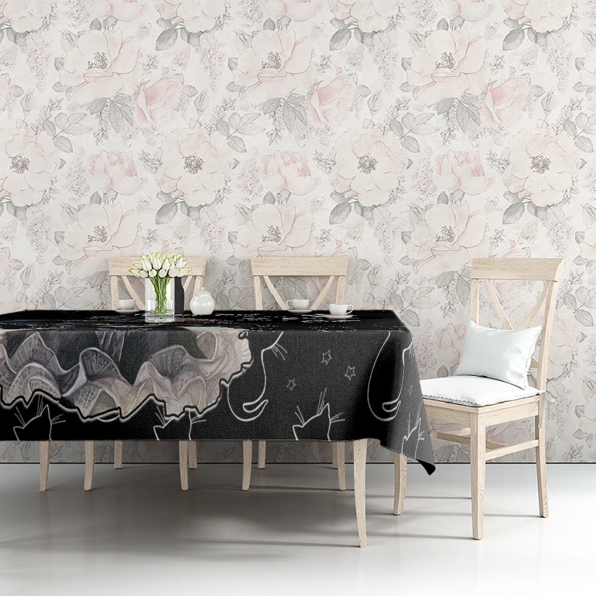 Black cat-pattern tablecloth draped over dining table in a floral setting