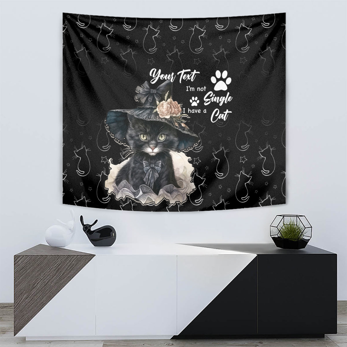 Black wall tapestry featuring a cat illustration in a hat with flowers and paw-print pattern