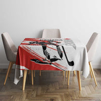 Red and white hockey-themed tablecloth on small dining table with four chairs