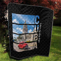Black quilt with diamond quilting and framed Cuba print of capitol building and red car