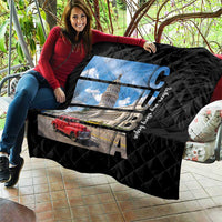 Black quilt draped on patio couch with diamond quilting and Cuba capitol print and red car