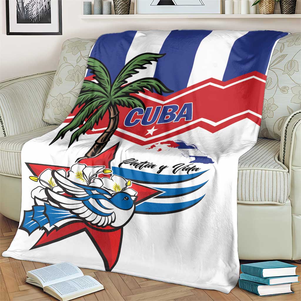 White blanket with blue and red striped banner, palm tree illustration, bird, and “Patria y Vida”